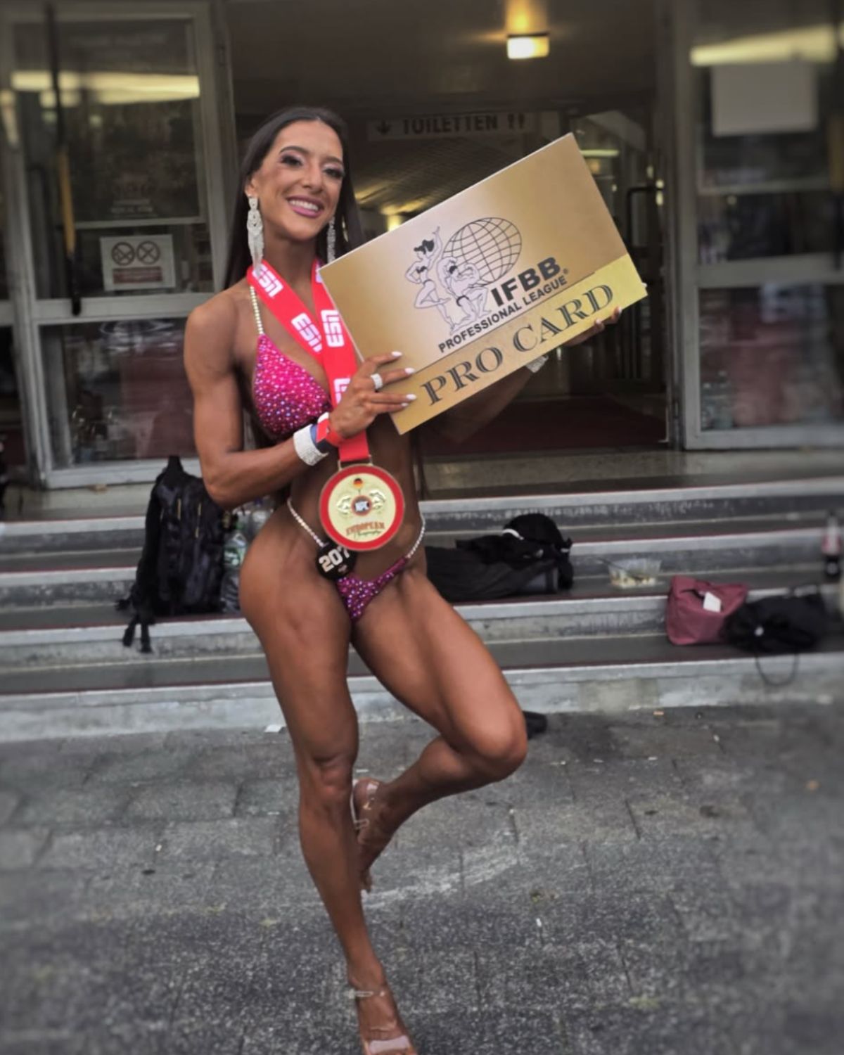 Ana Machado com o IFBB Pro Card no exterior da competição
